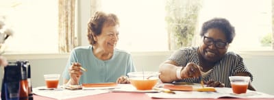 Two residents painting and enjoying an activity together.