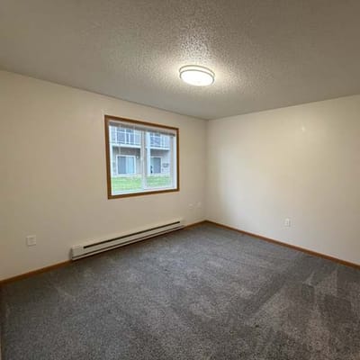 Empty, well-lit resident room with window