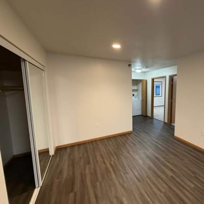 Empty room with hardwood flooring and closet