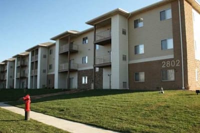 Exterior view of residential buildings and lawn.