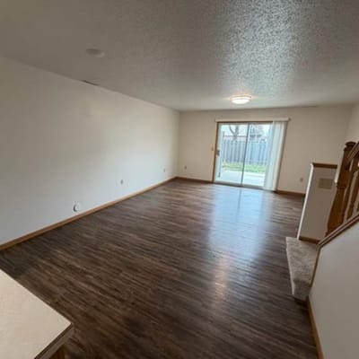 Empty living room with sliding door to outside.