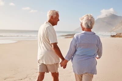A couple walking hand-in-hand on a beach