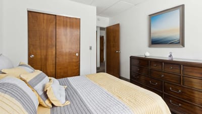 Well-decorated private resident room with a bed and dresser