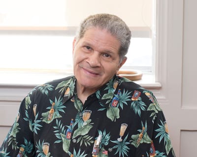 A smiling resident in a tropical print shirt