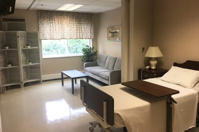 A comfortable resident room with a bed and sofa