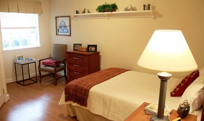 Well-furnished private resident room with a bed and chair