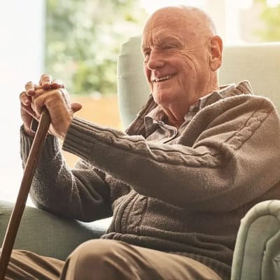 Senior man smiling while sitting in a chair