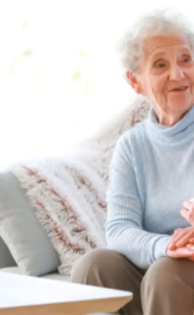 Happy elderly woman sitting in a cozy living area