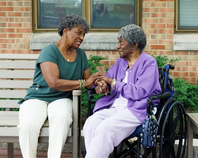 Two seniors sharing a warm moment outdoors.