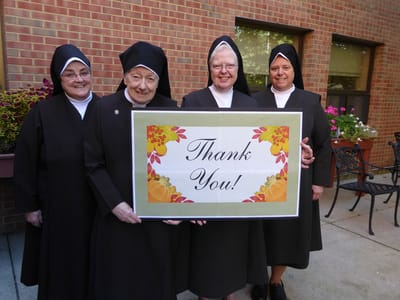 Group of four women holding a thank you sign