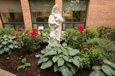 Statue surrounded by colorful flowers in a garden