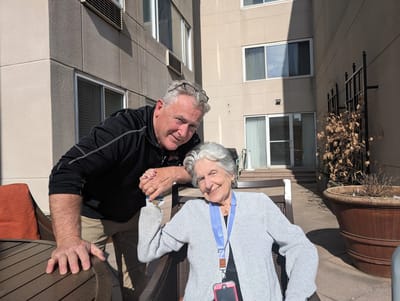 Staff member interacting with a resident outdoors.