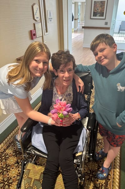 A woman in a wheelchair with two children
