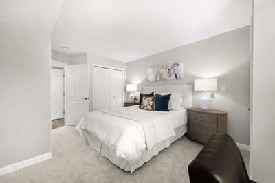 Cozy bedroom with a bed, nightstand, and decorative art.