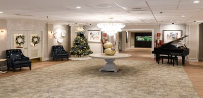 Elegant lobby with piano, Christmas decorations, and seating.