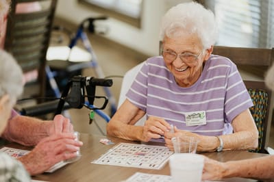 Senior residents playing bingo with joyful expressions.