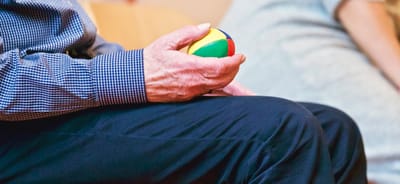 Close-up of a hand holding a colorful ball.