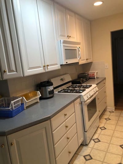 Bright kitchen with white cabinets and appliances.