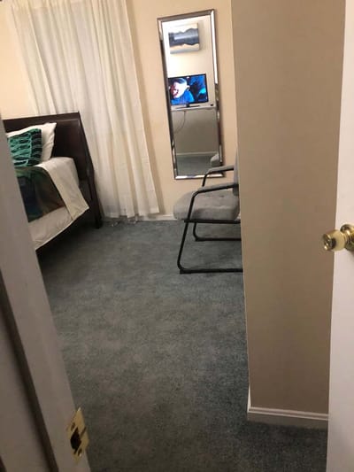 Private resident room with bed and mirror.
