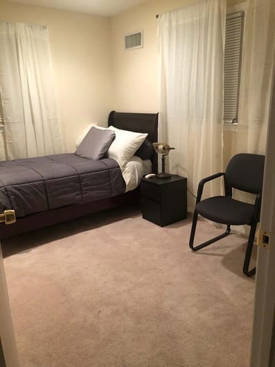Cozy bedroom with a bed and chair.