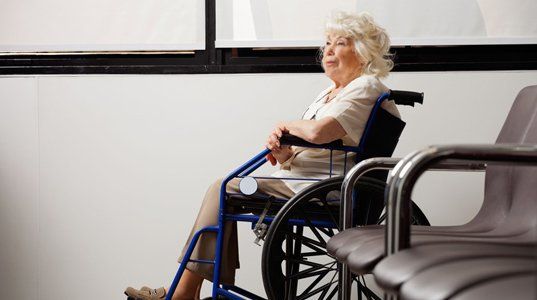 Senior resident in a wheelchair in a facility lounge