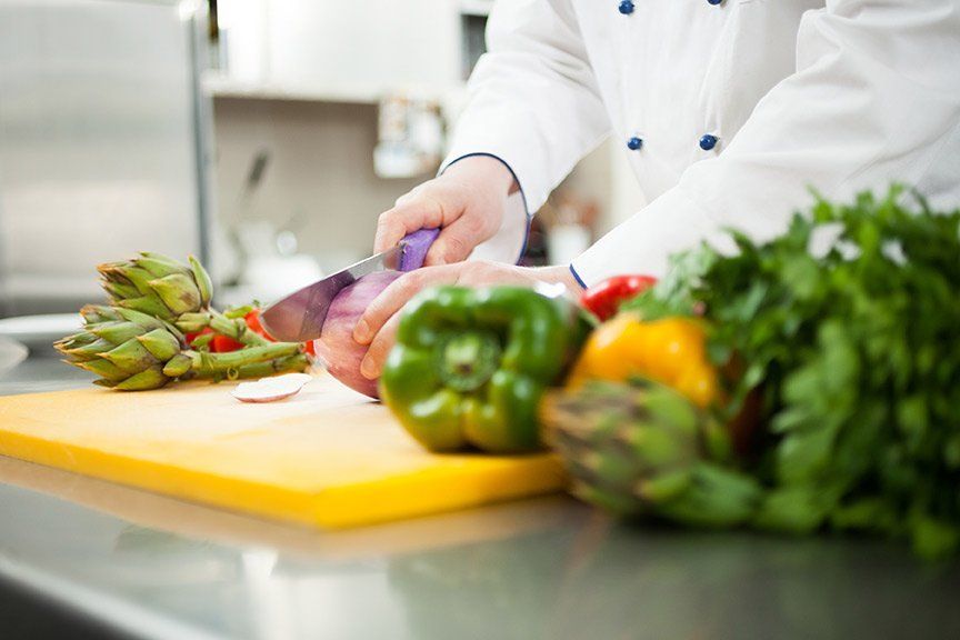 Chef preparing fresh vegetables in the kitchen.