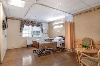 A private resident room with a bed and chair.