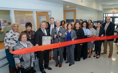 Ribbon-cutting ceremony with staff and community members.