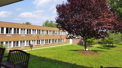 Exterior view of Southtowns Care Center with lawn and trees.