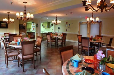 Bright dining area with tables and chandeliers.