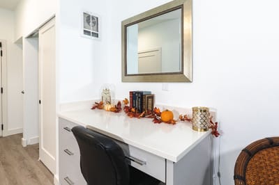 A well-decorated resident room with a desk and autumn decor