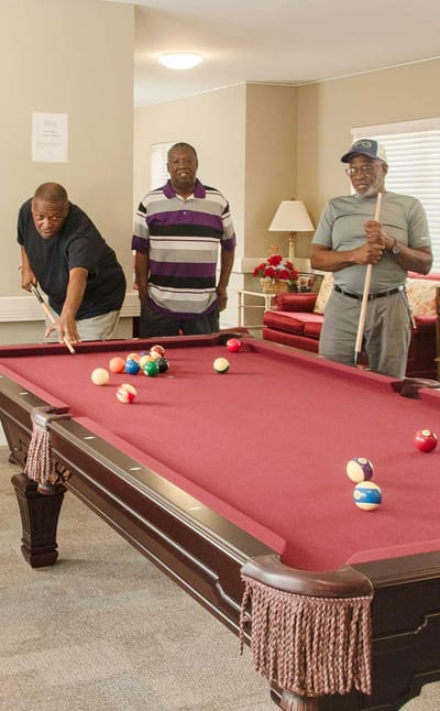 Residents playing billiards in a common area