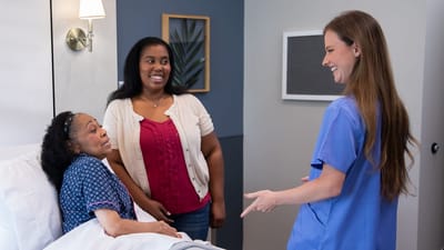Staff interacting with a resident and visitor in a room