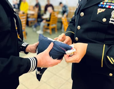 Ceremony of folding an American flag in a dining area