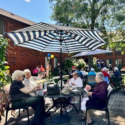 Residents enjoying an outdoor gathering under umbrellas