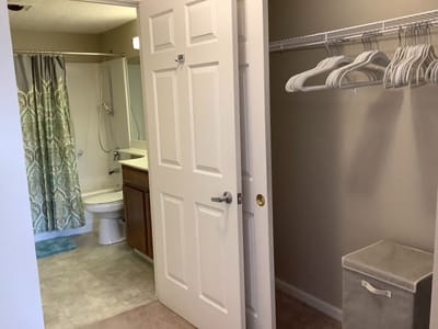 Brightly lit private resident bathroom and closet