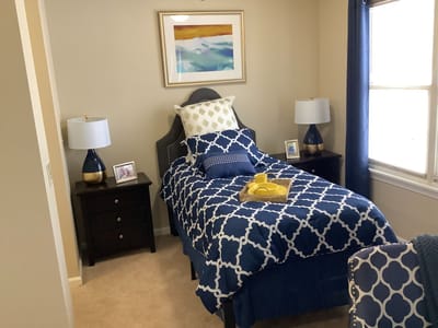 A cozy, well-decorated resident room with a single bed and lamps