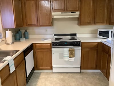Bright kitchen area with wooden cabinets and appliances