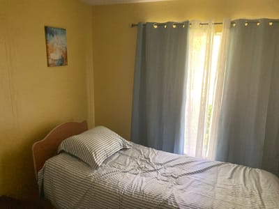 A simple bedroom setup with a bed and curtains