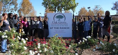 Residents and staff in front of the Oak Grove sign