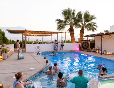 Residents participating in a pool exercise class at sunset