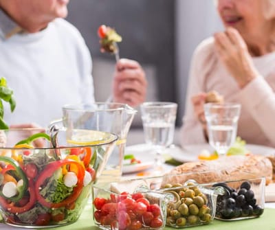 Residents enjoying a meal with a fresh salad