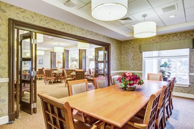 Bright and inviting common area with dining tables and floral arrangements