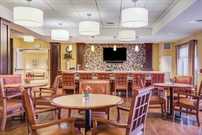 Bright dining room with wooden chairs and flower centerpieces