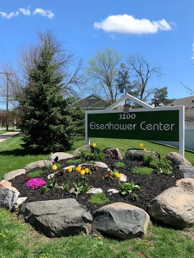Signage for Eisenhower Center with flowers and greenery