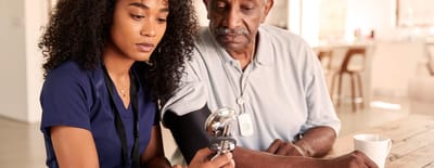 A healthcare professional consulting with an elderly resident