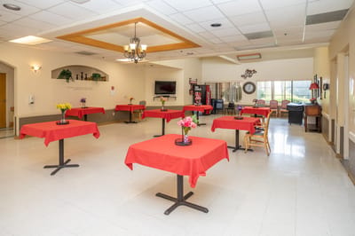 Bright common area with red table covers and flower arrangements