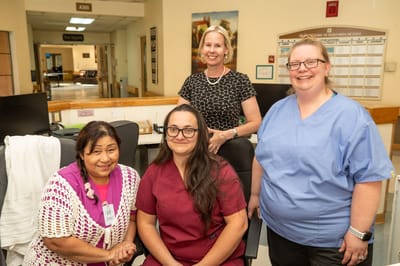 Staff and caregivers posing in a welcoming lobby area