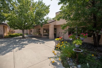 Exterior view of a senior living facility with gardens.