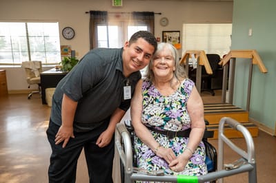 Staff member posing with a resident in a common area